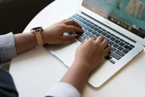 A medical transcriptionist typing on a computer, highlighting essential skills like accuracy, listening, and knowledge of medical terminology.