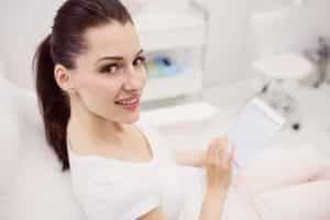taylor swift amas dental care woman smiling while holding tablet