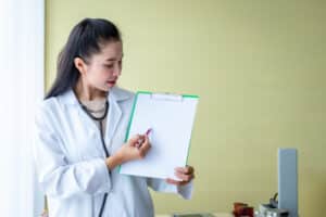 medical scribe duties woman doctor holding a pen and record