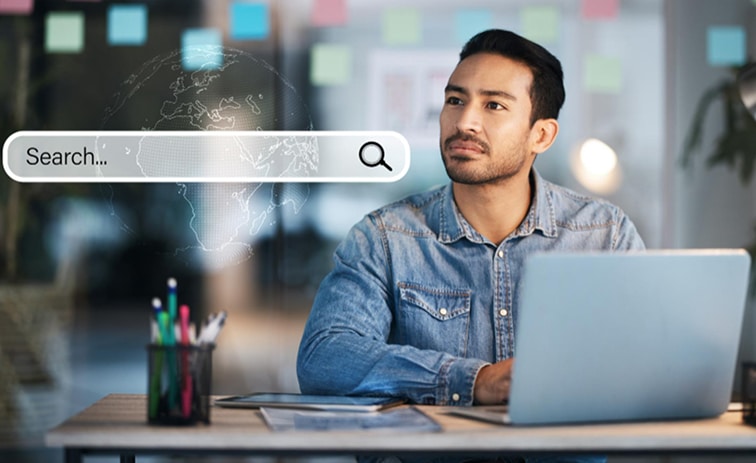 Man using laptop with search bar overlay for online research.