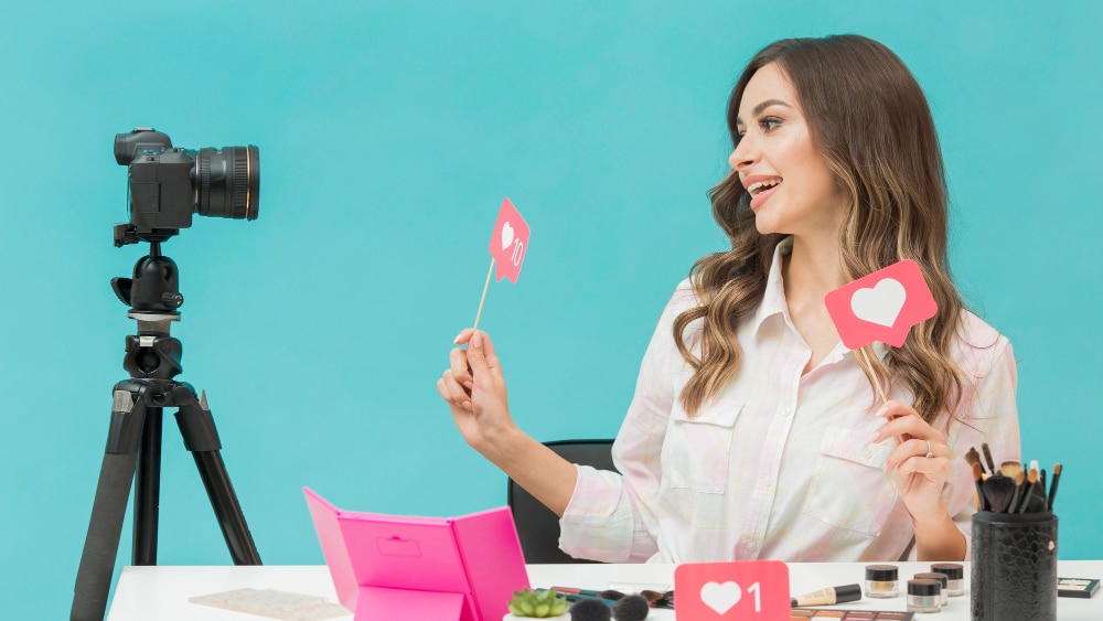 social media content manager woman in front of camera holding a heart react