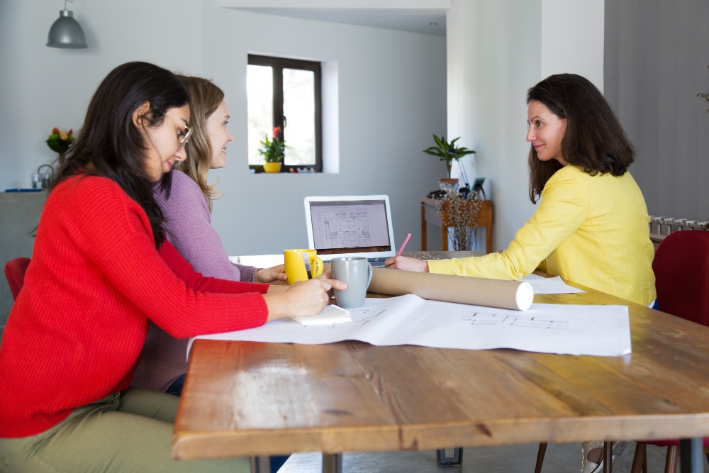 two woman staring and one woman writing