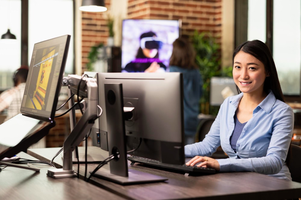 woman holding a mouse in front of monitor