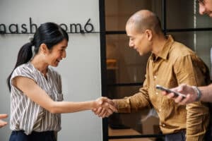 Smiling business professionals shaking hands in office