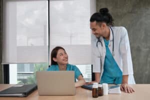 Two healthcare professionals in scrubs and lab coat