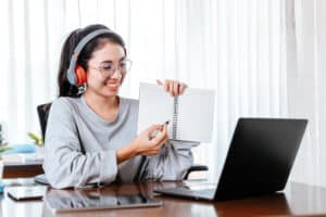 patient care coordinator duties Smiling woman with headphones attending an online meeting