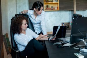 personal assistants cost Two businesswomen discussing documents