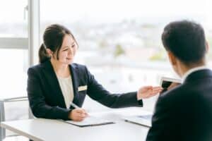 real estate transaction coordinator Smiling businesswoman presenting data on a laptop to a colleague