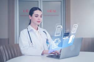 virtual medical billing solutions A female doctor working on a laptop with floating digital icons