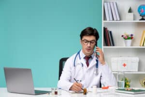 virtual medical billing solutions a male doctor in a white coat is sitting at his desk