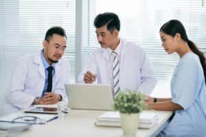 what do medical receptionist do Group of doctors and a nurse discussing patient care