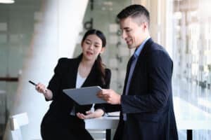 what does executive assistant do Two business professionals in formal attire reviewing information