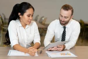 what does executive assistant do Two business professionals reviewing financial reports and discussing data
