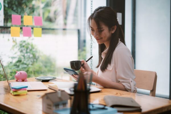 what does executive assistant do Young woman working at a desk with a notebook and coffee cup