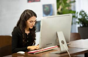 what is an er scribe Female virtual assistant using computer with headset in office.