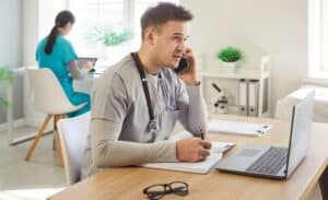 Male healthcare professional with stethoscope talking on phone