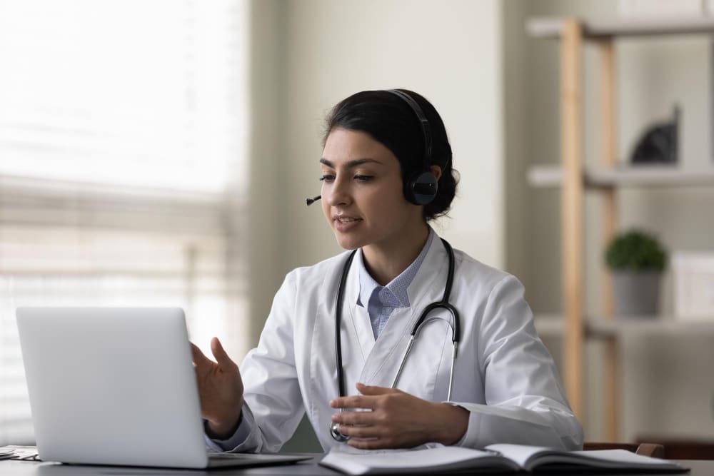 bilingual virtual assistant woman wearing a headset in front of laptop