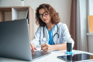 hire a hipaa compliant virtual medical assistant today Female doctor with stethoscope working on laptop