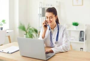 virtual assistants for telehealth practices Female doctor with stethoscope using laptop