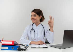 virtual medical assistant companies Smiling female doctor with stethoscope showing OK