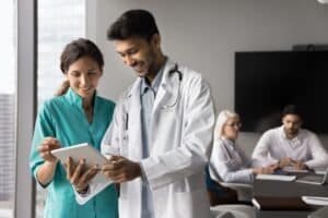virtual patient care coordinator Smiling doctors reviewing patient information on a digital tablet