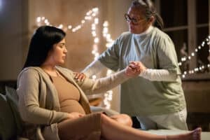 A caregiver supports a pregnant woman, reflecting maternity obstetrical care medical billing