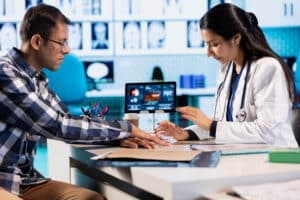 A doctor examines a patient’s hand in a clinic, emphasizing accuracy in the Speech Therapy Billing and Coding Guide
