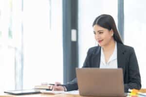 Professional woman working on a laptop at a bright modern office desk
