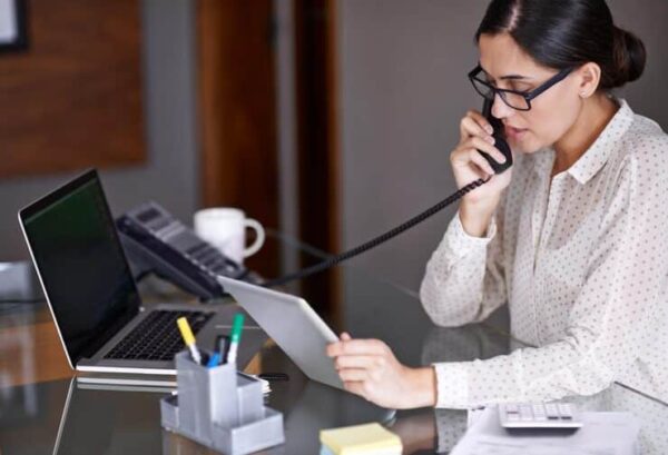 female receptionist talking to her patient through phone