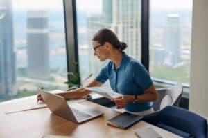 how medical virtual assistants shorten admin backlogs healthcare assistant facing laptop and doing paperworks