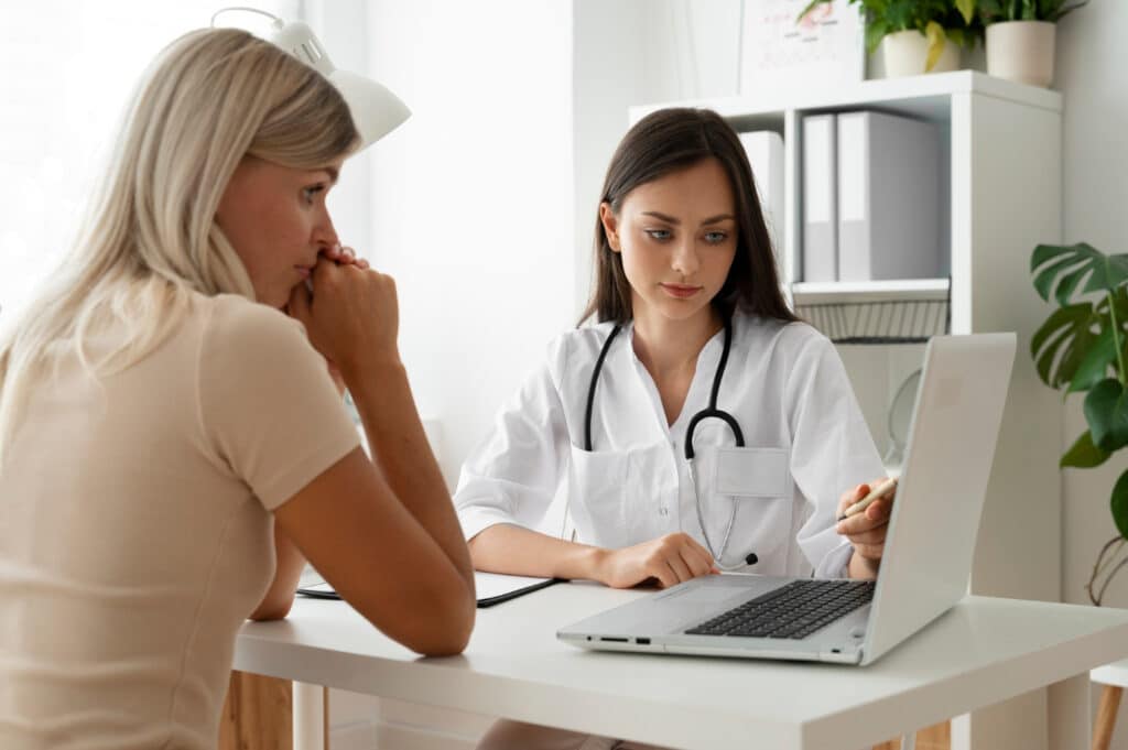 Patient at the clinic during a specialty clinic discharge follow-up workflow, receiving clear post-visit care instructions and support.