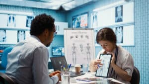 Doctor presenting lab test results to a patient during a patient care coordinator follow-up workflow in a healthcare clinic.