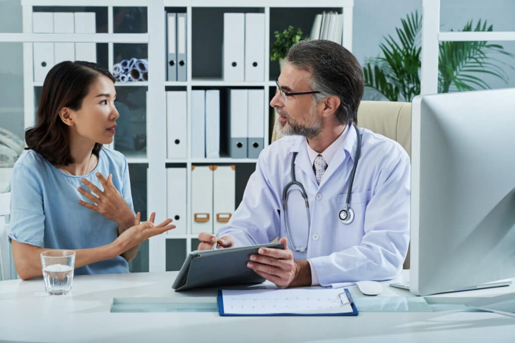 Patient trust before the first appointment as a patient discusses disease symptoms with a doctor during a medical consultation.