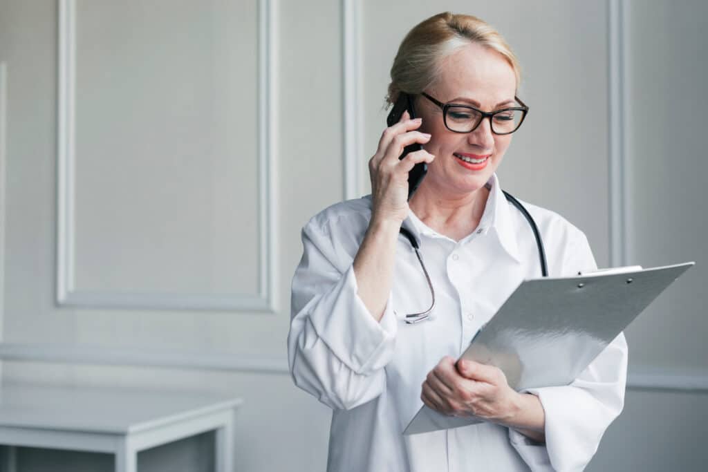Doctor reviewing a medical report as part of a faster patient callback workflow for clinics.