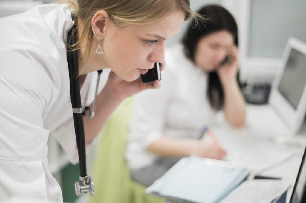 Doctor speaking on the phone using a patient follow-up call system for medical practices.
