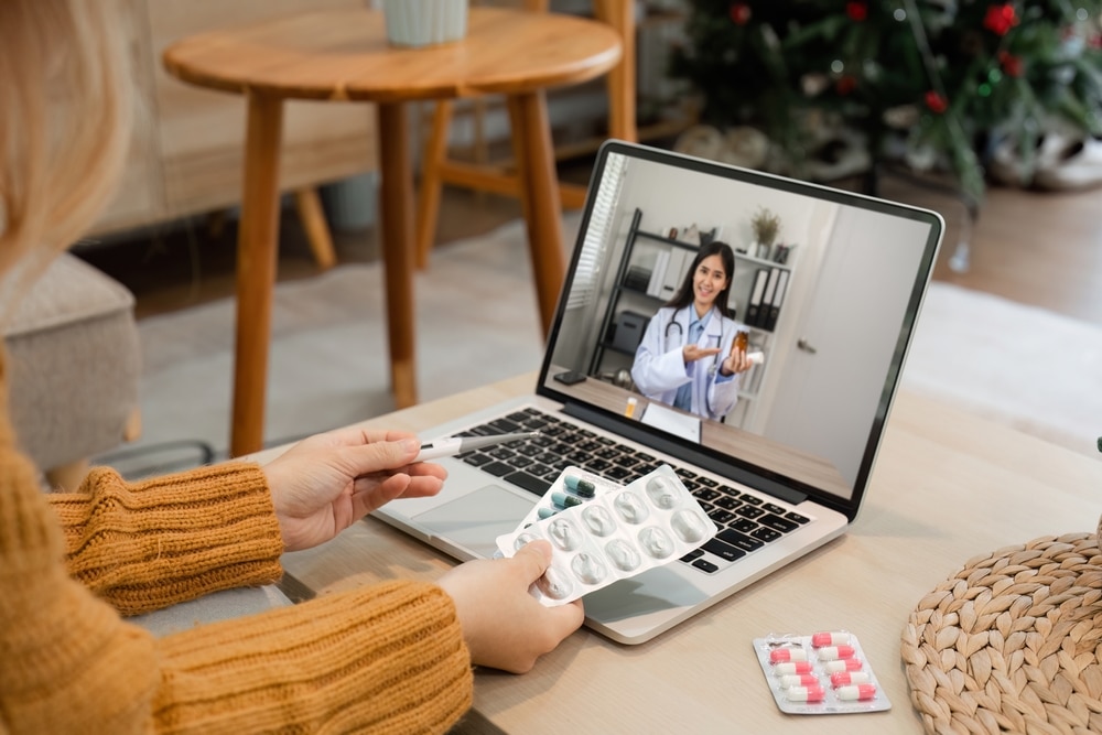 Female physician giving a virtual medical consultation via video call using a laptop