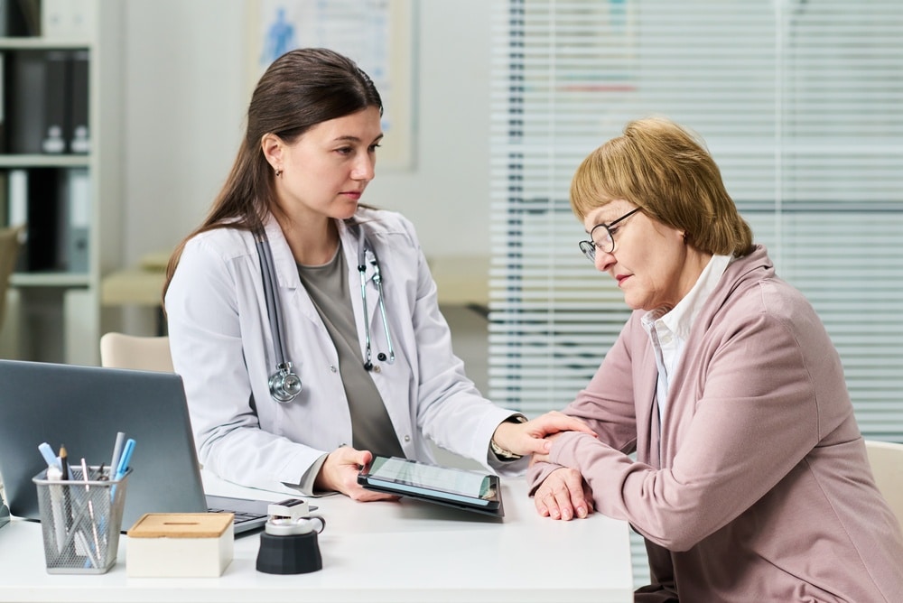 Young female physician talking with an elderly woman patient during a medical consultation in a clinic