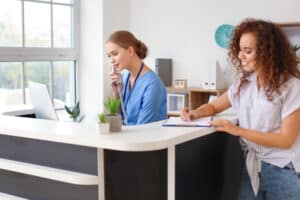 Young female receptionist talking on the telephone in a clinic