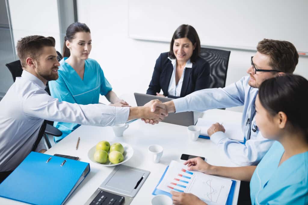 Doctors shaking hands with each other after a successful medical mission.