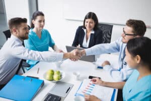 Doctors shaking hands with each other after a successful medical mission.