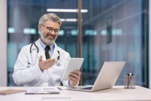 Doctor reviewing digital records for insurance document follow-up for medical offices.
