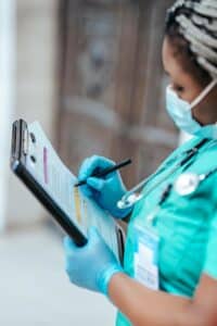 Healthcare professional documenting patient information to support bilingual portal message routing for medical practices.