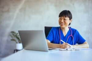 Healthcare professional documenting referral details for specialist referral document retrieval without provider interruptions.