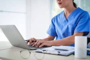 Healthcare professional documenting referral messages for an after-hours referral message triage workflow for specialty clinics.