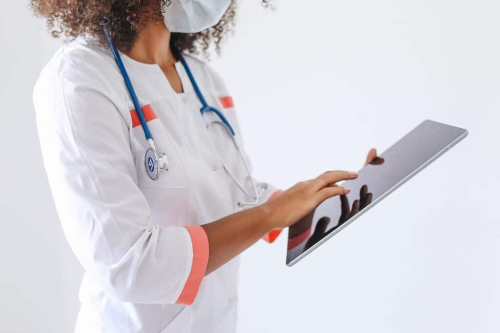 Healthcare professional using a tablet to support bilingual front desk service recovery for medical practices.