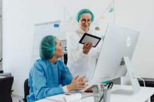Healthcare professionals coordinating digital records for medical virtual assistant referral leakage reduction.