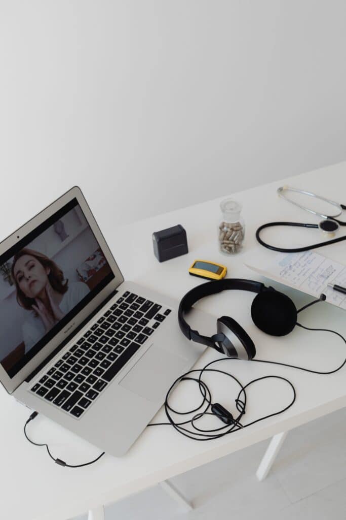 Telehealth workstation with a laptop, headset, and medical equipment supporting local search intake readiness for high-intent patients.
